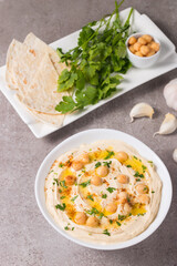 Hummus in a plate with chickpeas, smoked paprika, olive oil and pita. Vegetarian food.