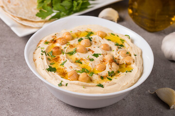 Hummus in a plate with chickpeas, smoked paprika, olive oil and pita. Vegetarian food.