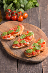 Tomato and basil fresh made bruschetta. Italian tapas, antipasti with vegetables, herbs and oil on grilled ciabatta and baguette bread. Sandwich.