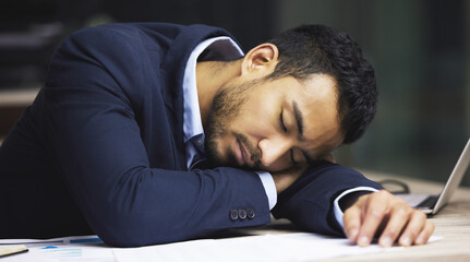Ive finally hit a wall. Shot of a male stock broker having a nap at his desk.