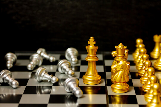 Gold King chess figure and team win silver chess figure on board, team work and management or leadership concept.