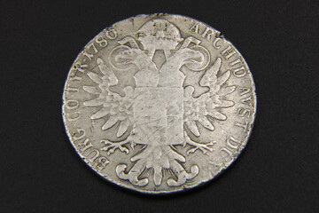 Old Austrian silver coin on black background