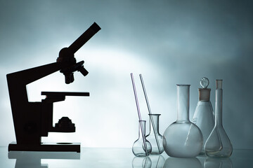 Laboratory test tubes. Glass flasks next to microscope. Scientific concept. Empty test tubes in...