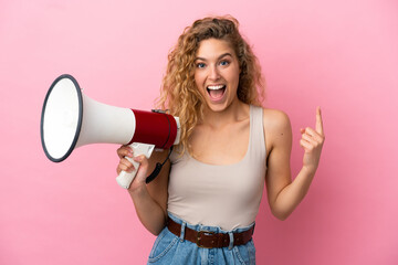 Young blonde woman isolated on pink background holding a megaphone and pointing up a great idea