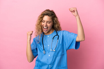 Young surgeon doctor woman isolated on pink background celebrating a victory