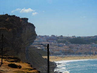 Beach landscape on a sunny day, with view to the city from a mountain. Nazare, Portugal