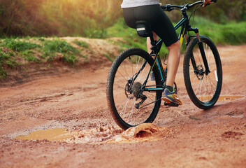 Fototapeta na wymiar What an exhilarating hobby. Shot of a female mountain biker out for an early morning ride.