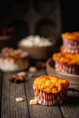Sweet homemade cottage cheese muffins with pumpkin on dark wooden background