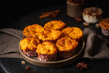Sweet homemade cottage cheese muffins with pumpkin on dark wooden background