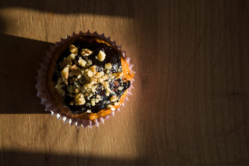 cupcake with chocolate glaze and nut sprinkles