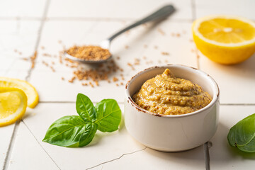 Fresh homemade organic dijon mustard in a bowl on white background, close up