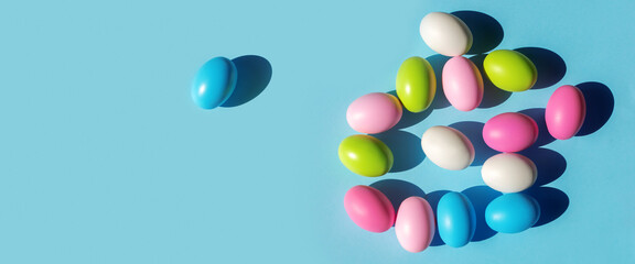 Multicolored painted Easter eggs on blue paper background. Flat lay  top view with copy space. Banner for congratulations.