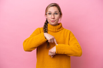 Young caucasian woman isolated on pink background making the gesture of being late