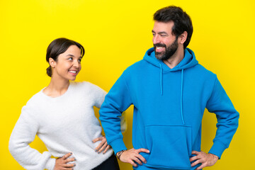 Young caucasian couple isolated on yellow background happy and smiling