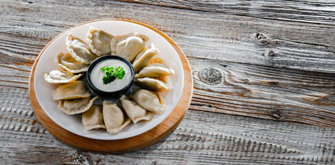 Composition with a plate of classic pierogies with sour cream