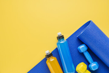 Isotonic energy drink. Bottle with blue and yellow transparent electolytes liquid, sport beverage sportmate on a yellow background. It usually contains salt and sugar and maintains optimal hydration