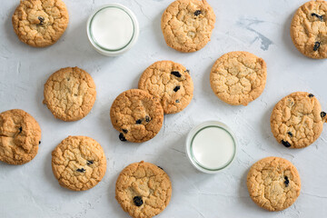 Cookies with chocolate and milk in a glass in the form of a pattern on a light table. An idea for a children's breakfast or snack. Flat lay, top view.