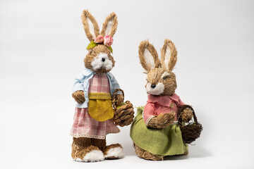 Couple Easter Decorations Hare Rabbits of straw. Easter toy rabbit made of straw with a basket isolated on a white background