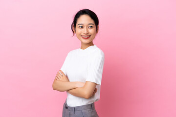 Fototapeta premium Young Vietnamese woman isolated on pink background with arms crossed and happy