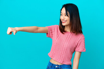 Fototapeta premium Young Vietnamese woman isolated on blue background giving a thumbs up gesture