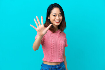 Young Vietnamese woman isolated on blue background counting five with fingers
