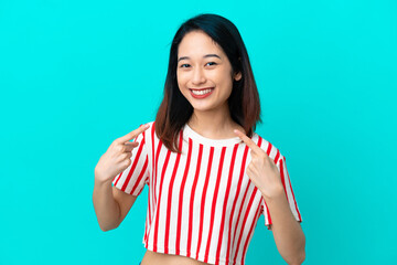 Young Vietnamese woman isolated on blue background giving a thumbs up gesture