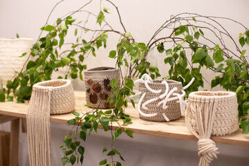 Knitted beige baskets on wooden table. Handmade. Round knitted pots made of jute. Crochet eco boxes for home. Concept natural craft decoration at home. cozy details interior boho decoration at room. 