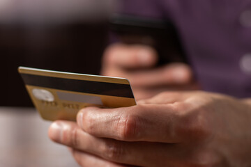 Man holding credit card making e bank online payment. Consumer paying for purchase using smartphone technology.
