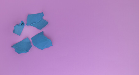 A bunch of balls of crumpled purple paper on a pink background. The concept of minimalism, a copy of the space on the right