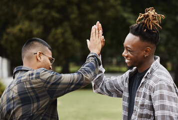 Put it up top. Shot of two young men giving each other a high five on campus.