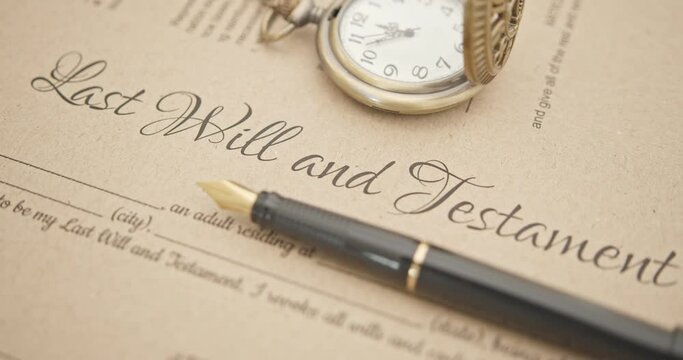 Last will and testament, legacy, inheritance or death tax concept : Fountain pen, a pocket watch on a last will and testament. A form is waiting to be filled and signed by a testator or testatrix.