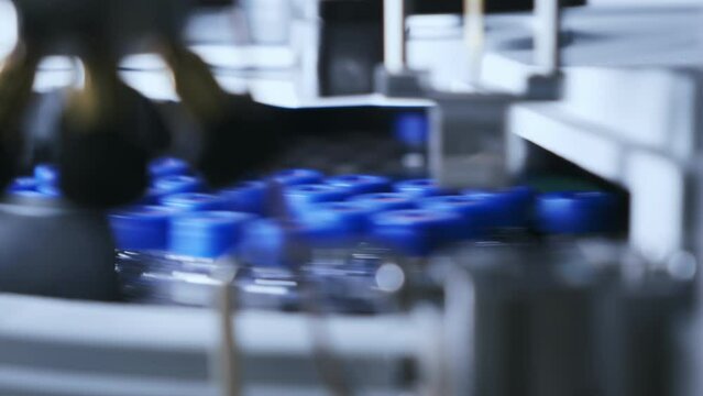 HPLC Autosampler revolves collecting samples analysis. Glass vials with blue caps at laboratory. Chromatographic separation of compounds extreme closeup