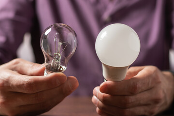Two lamps in the hands of a man. Incandescent light bulb and LED light bulb in your hands.