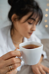 Portrait of smiling happy cheerful beautiful pretty asian woman relaxing reading a book enjoy of rest.Young student girl studying with book in holiday morning vacation on bed at home with copy space