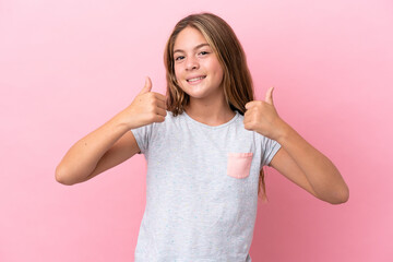 Little caucasian girl isolated on pink background giving a thumbs up gesture