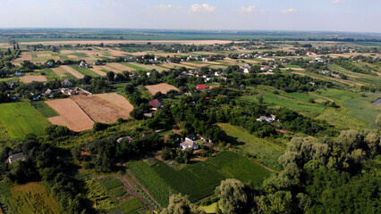 Fototapeta na wymiar Beautiful Ukrainian landscape. Village among sown fields and gardens. Aerial view