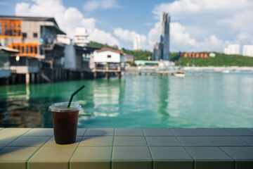Ice Americano black coffee with blur Pattaya view at cafe