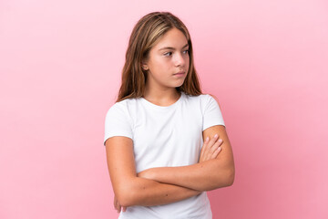 Little caucasian girl isolated on pink background keeping the arms crossed