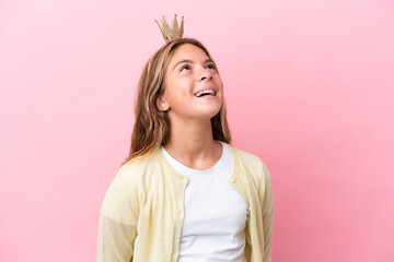 Little princess with crown isolated on pink background laughing