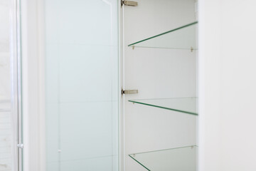 white furniture with metal hinges and glass shelves
