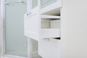 Fototapeta na wymiar white pull-out shelves made of wood in the bathroom