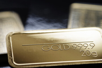 Minted gold bar weighing 20 grams. Selective focus.