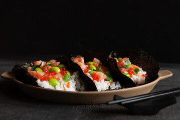 Trendy Hybrid Food Sushi Tacos with salmon, rice and edamame beans.