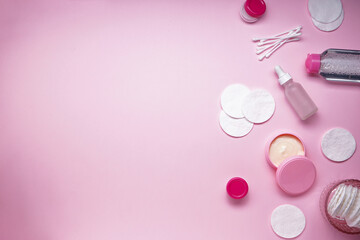 Cotton pads, cotton buds and cosmetic on a pink background with space for text. Spa concept.