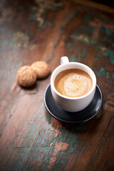 Cup of coffee with Amaretti (Italian biscuits) on rustic wooden background. Copy space.                                                                           