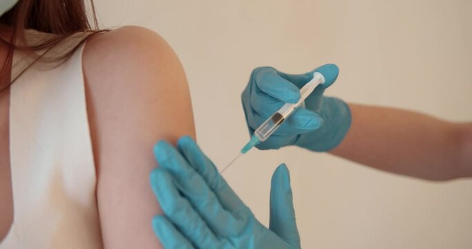 Girl in a mask getting injection on beige background