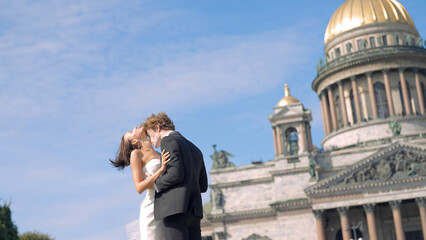 Photosession of a beautiful elegant wedding couple on the background of St. Isaac 's Cathedral. Action. Loving Bride and groom embracing at the historical center of Saint Peterburg, Russia.