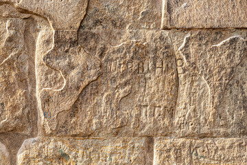 Old walls of the temple with half-erased inscriptions