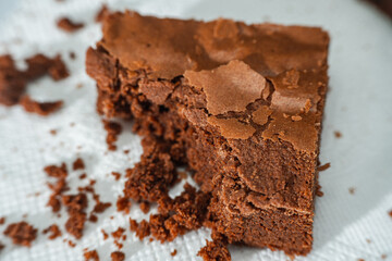cubes of chocolate brownies on a white plate on a marble table.