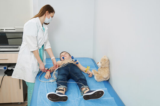 Female pediatrician performing electrocardiogram test in clinic